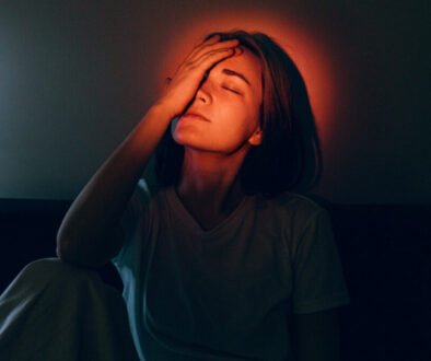 Woman with hand on forehead surrounded by a glowing light, symbolizing renewing the mind