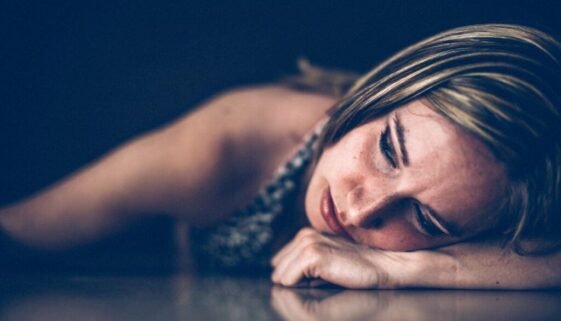 Woman lying down in quiet emotional pain during a season of depression