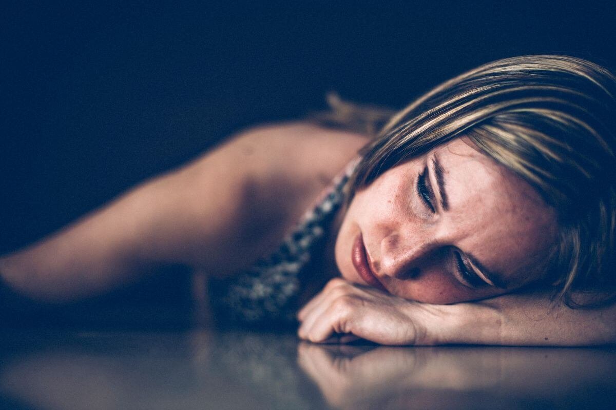 Woman lying down in quiet emotional pain during a season of depression